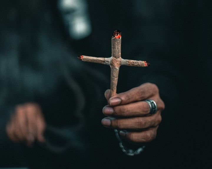 Ein Mann hält einen komplizierte gebauten Kreuz Joint in die Kamera
